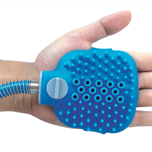 A blue silicone hand scrubber with a flexible metal hose attachment, held in a person's hand against a white background.